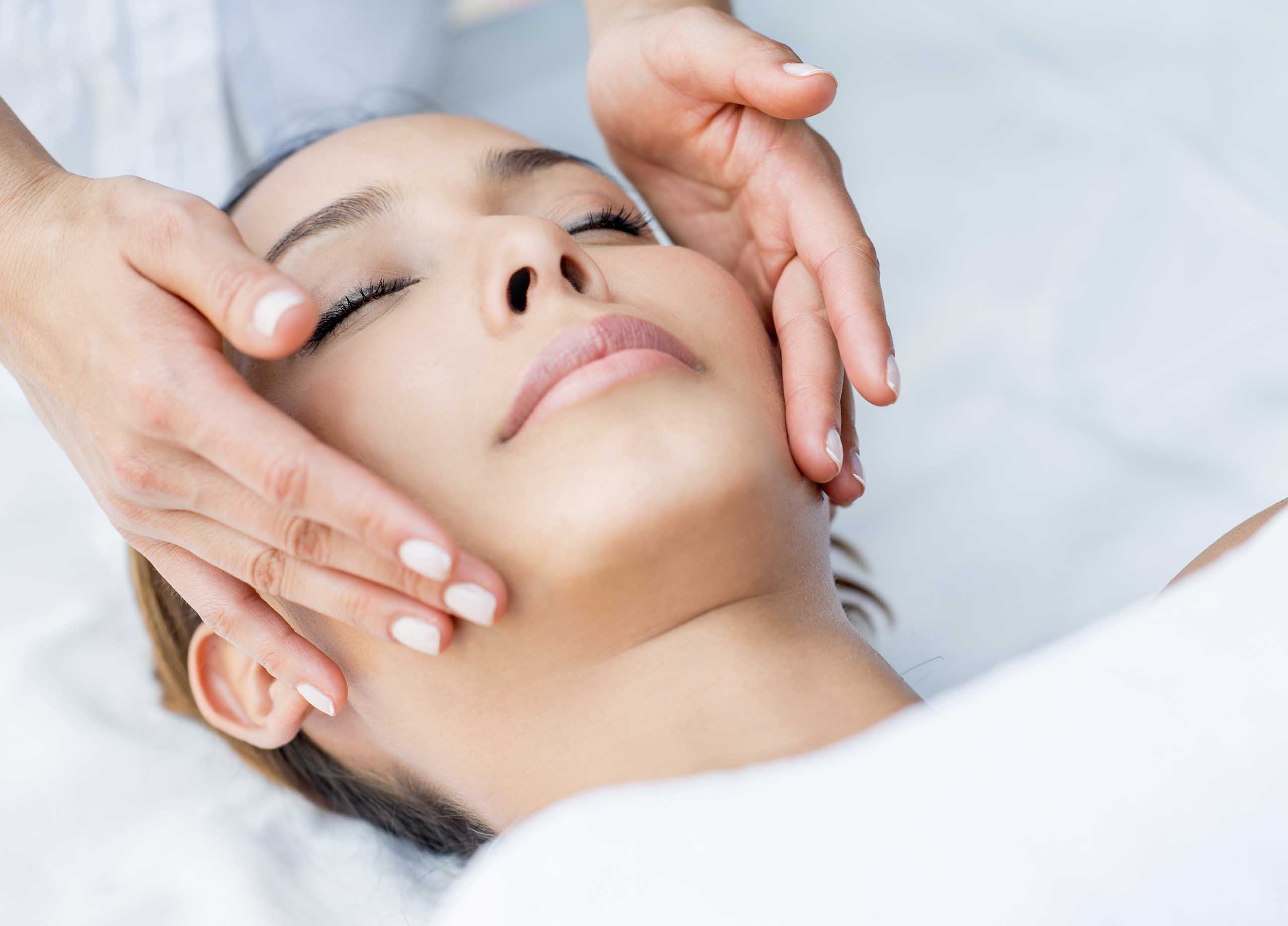 a women sitting down receiving skin care treatment that contains hyaluronic acid