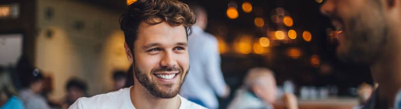 Man out in public smiling after microneedling for his hair in cambridge